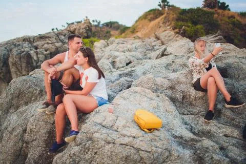 Disloyal man walking with his girlfriend and looking amazed at another seductive Stock Photos