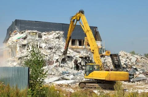 Dismantling of concrete structures, excavators break down old buildings Stock Photos