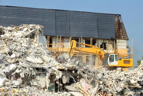 Dismantling of concrete structures, excavators break down old buildings Stock Photos