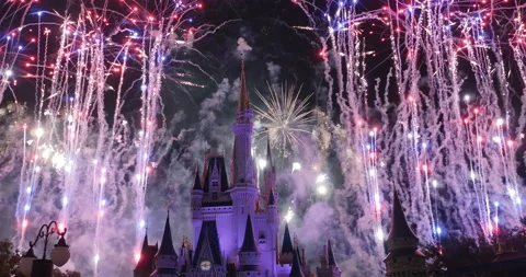 Disney World Magic Kingdom July 4th colorful fireworks display behind castle Stock Footage