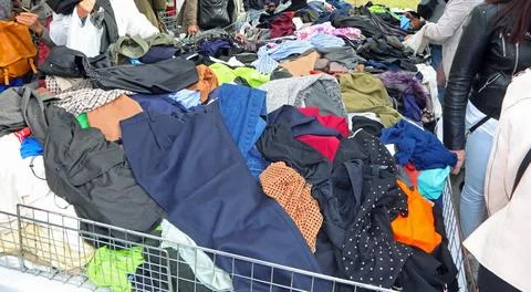 Disorganized stack of various pre owned fashion garments and outfits at an .. Fotos Stock