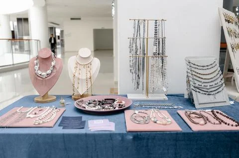 Display of assorted jewelry on table with elegant presentation in showroom Stock Photos