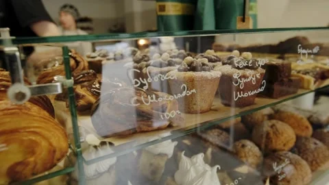 A display case in a coffee shop filled with freshly baked, hot pastries. Stock Footage 267015206
