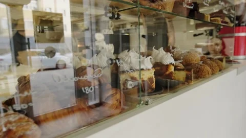 A display case in a coffee shop filled with freshly baked, hot pastries. Stock Footage 267015339