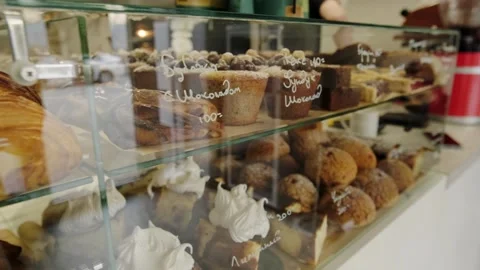 A display case in a coffee shop filled with freshly baked, hot pastries. Stock Footage 267015977