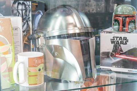 Display case with a large silver Star Wars Mandalorian helmet ridged, pointed Stock Photos