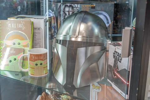 Display case with silver Star Wars Mandalorian helmet, green-bodied figurines Stockfoto's