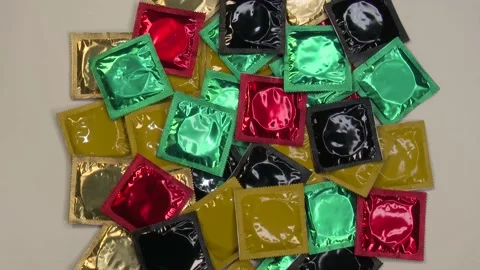 Display of colored condoms on a rotating platform arranged in bulk Stock Footage 132503237