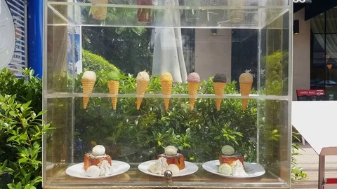 Display of ice cream in cones, cake plates, transparent casing, Vientiane, Laos Видео 75826346