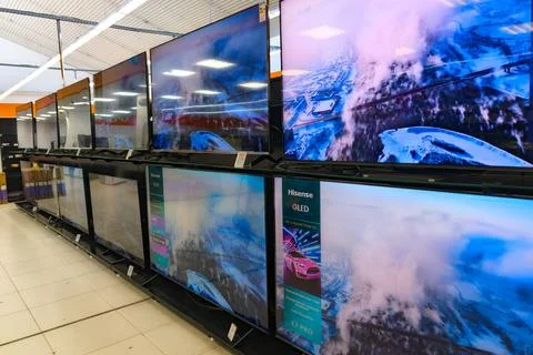 Display of multiple large-screen televisions in an electronics store during the Stock Photos