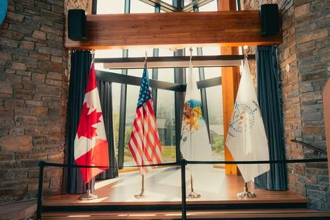 A display of national flags from multiple countries on display indoors. Stock Photos