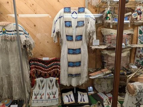 Display of Native American dresses, beadwork vests, knives, and purses Stock Photos