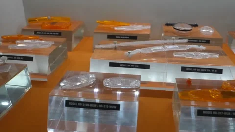 Display of orange translucent injection molded plastic sample parts on labeled Stockbeeldmateriaal 340901851