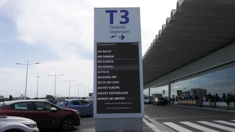 Display outside Fiumicino airport indicating Terminal 3 and airlines Stock Footage 160966279