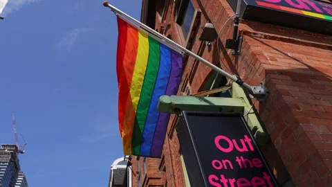 Display of a Rainbow Flag on a Building Promoting LGBTQ+ Pride and Inclusivity Stock Footage 257099696