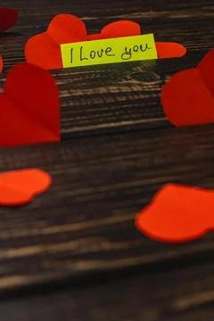Display of red hearts and a note saying I love you on a wooden table Stock Photos