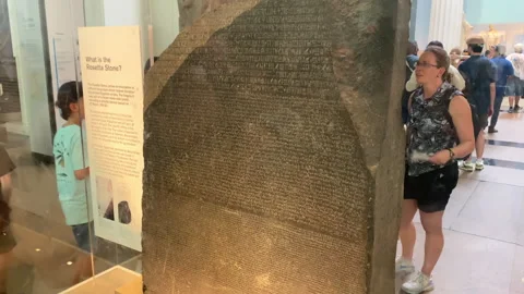 Display of the Rosetta Stone inside the British Museum surrounded by visitors Stock Footage 321460340