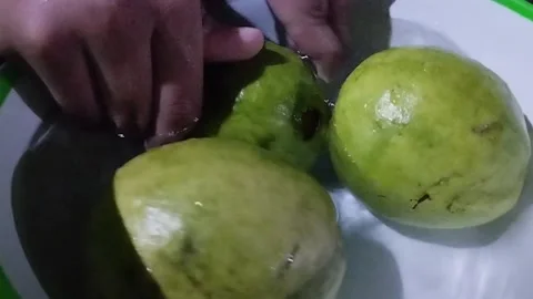 Display of three red crystal guavas cleaned in a bowl Stock Footage 229249792