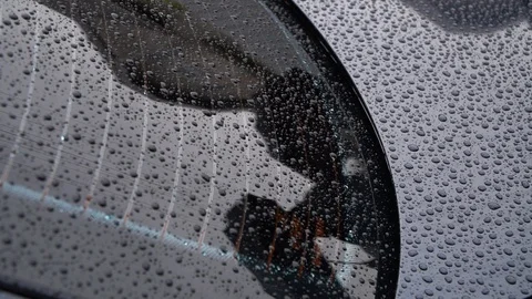 Display of umbrellas in the window of the car.Window in rain drops Stock Footage 127431533