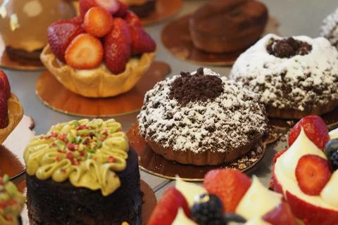 Display of various desserts at a bakery with different decorations and flavors Stock Photos