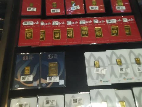 A display of various gold bars and gold-plated items in a retail setting, s.. Stock Photos