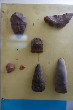 A display of various objects, including a rock with a hole in it, is on a t.. Fotos Stock