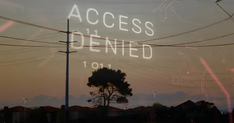Displaying ACCESS DENIED and binary code over suburban dusk rooftops with pole 스톡 사진