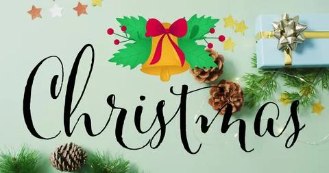Displaying black script Christmas word on mint-green surface with golden bell, Stock Photos