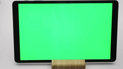 Displaying blank green screen on tablet positioned on wooden stand Stock Footage 295003120