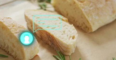 Displaying crusty bread slice on parchment on wooden countertop, with rosemary Stock Photos