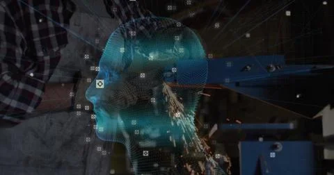 Displaying cyan hologram head with sensor icons over metal shop, worker wearing 스톡 사진