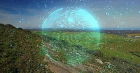 Displaying digital holographic globe floating above hillside, near rocky Ilustração Stock
