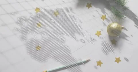 Displaying dotted world map of perforations on white grid paper desk, with gold Stock Photos