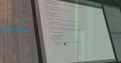 Displaying dual monitors showing JavaScript code editor windows on office desk, Stock Photos