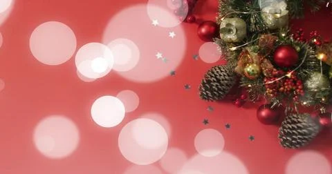 Displaying evergreen wreath on red backdrop with pine cones, baubles, star Stock Illustration
