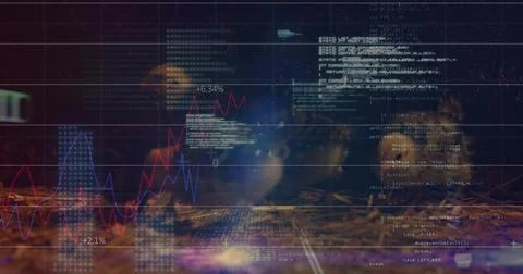 Displaying financial charts and code overlays in dim workspace with red and blue Foto stock