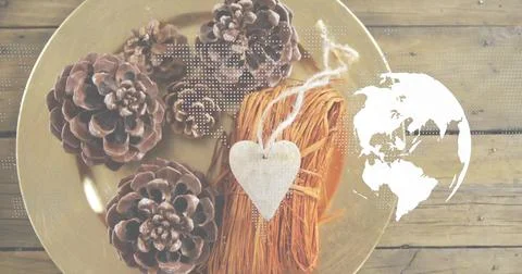 Displaying flat-lay with four pine cones, bound straw and white heart on gold Stock Photos