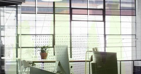 Displaying floor-to-ceiling grid glass windows projecting code overlay in open Stockfoto's