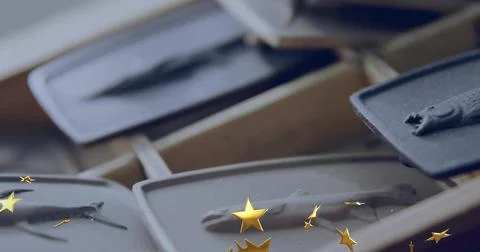 Displaying gray rectangular trays holding small fish-shaped casts on wooden rack Stock Photos