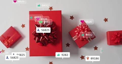 Displaying large red gift box occupying center of gray tabletop, with floating Stock Photos