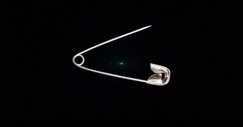 Displaying metallic silver safety pin holding spring coil open on studio blac Stock Illustration