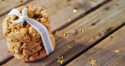 Displaying oatmeal cookie stack tied with pale ribbon on worn wooden plank, gold 스톡 사진