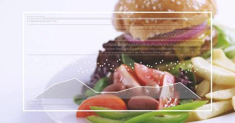 Displaying plated meal on studio tabletop featuring leafy salad, sesame bun and Stock Photos