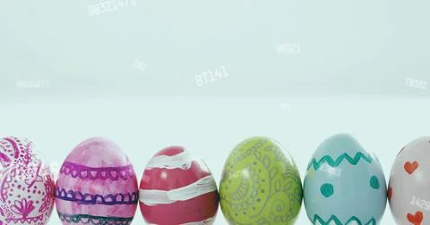 Displaying row of painted glossy eggs on white table with pale blue gradient and Stock Photos