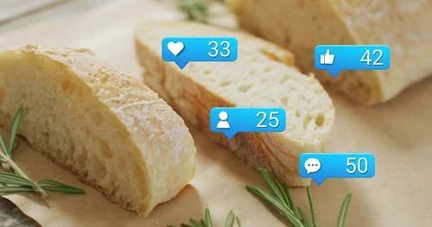 Displaying sliced rustic bread on brown paper on table, with rosemary and four Stock Photos