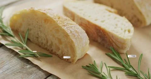Displaying sliced rustic bread resting on weathered wooden table, with parchm Stock Photos