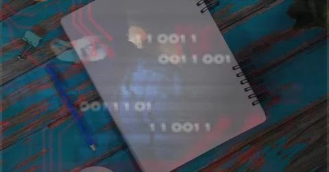 Displaying spiral notebook on desk with binary overlay, circuit graphics and Stock Photos