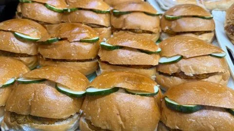 Displaying a tempting array of golden brown burgers, each adorned with a cucu Foto stock