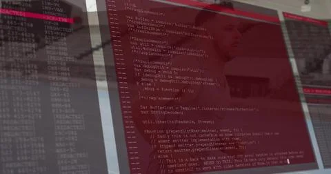Displaying three monitors showing red terminal code at office desk, reflecting Stock Photos