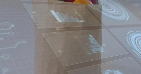 Displaying translucent panels over glass panel in office, showing blue charts 写真素材